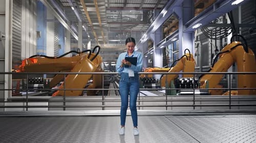 Woman Using Tablet in Robot Manufacturing Factory