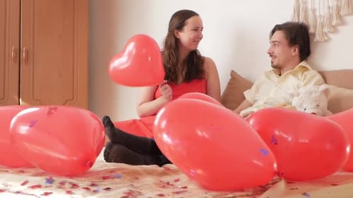 Couple Celebrating Together with Heart Balloons