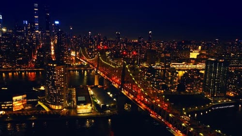 Flying over the East River near the Queensboro Bridge with amazing illumination at night.