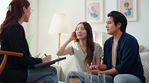 Couple Holding Hands Talking to Therapist Indoors