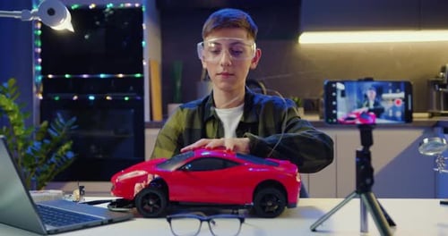 Teen Repairs Toy Car While Vlogging at Home