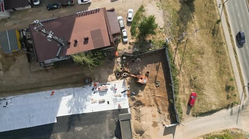 Excavator Digs Soil with Bucket at Construction Site in City