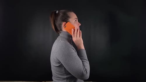 Uma mulher interagindo com um objeto isolado no fundo preto