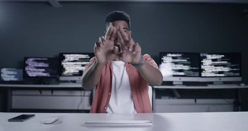 4k footage of a young male programmer drawing on a transparent screen while working late at night