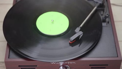 Close up of a Vinyl Record Spinning with green screen croma on vinyl cover.