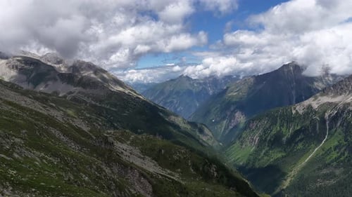 Aerial View of a Stunning Green Mountain Valley Under a Cloudy Sky