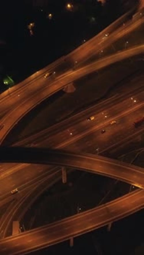Vidéo verticale de l'échangeur routier à plusieurs niveaux illuminé