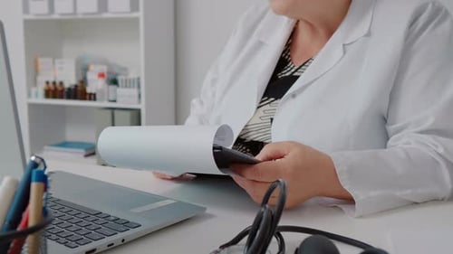 Female doctor doing paperwork in the office.