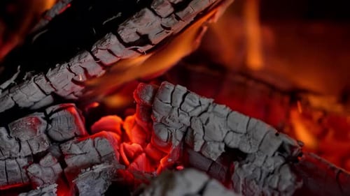 An einem gemütlichen Abend glüht die Glut sanft in einem warmen Feuer