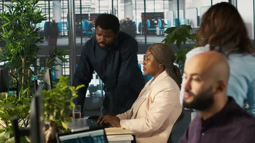 Teamarbeitende Kollegen im Büro analysieren Datendiagramme auf dem Computerbildschirm