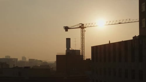 Static view of an Urban construction site with crane in Barcelona, Spain at sunset.