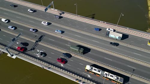 Aerial view of road bridge highway across the river in city area. Lorry is driving on the bridge. Sk