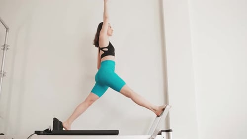 Woman Training on Pilates Reformer Machine