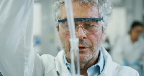 Man Scientist Carefully Dispensing Liquid in Laboratory