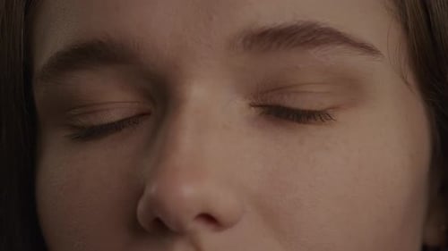 Close Up of a Caucasian Woman Eyes in a Wink or Blink Gesture in Slow Motion Indoors