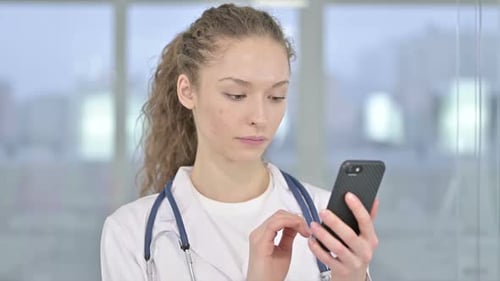 Female Doctor Using Phone in Modern Hospital Setting