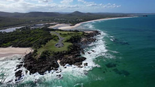Aerial Drone Shot of Rugged Coastline Waves and Green Peninsula