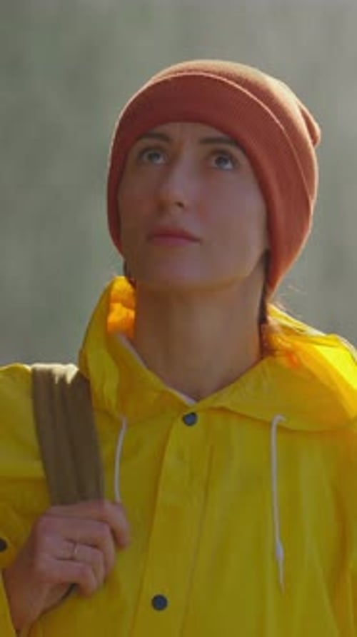 Woman in Yellow Raincoat Looking Upward