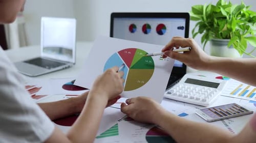 Business Professionals Analyze Charts in Office Workplace