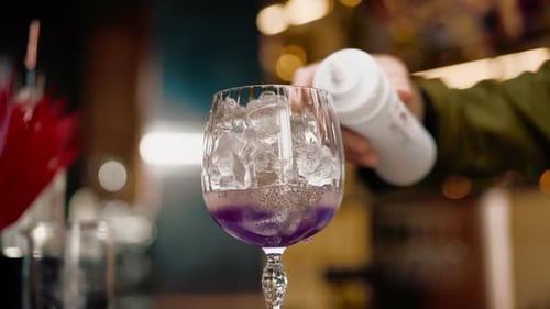 professional bartender creates a cocktail drink pours alcohol into a measuring glass at the bar