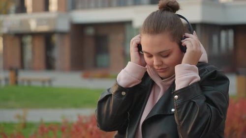 Woman Adjusts Headphone Enjoying Peaceful Morning Breeze Outdoors