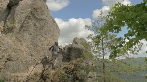 Man Climbs Rocky Outcropping in Wilderness Area
