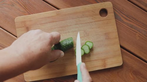Slicing a Cucumber on Cutting Board