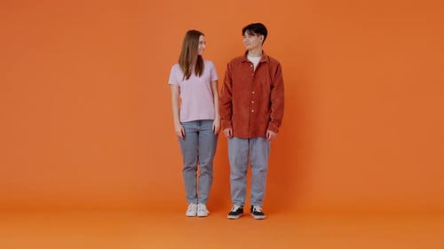 Cheerful Asian Man and European Woman Cross Arms in Studio