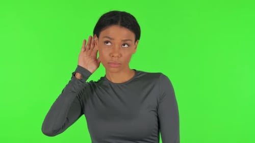 African Woman Trying to Listen on Green Background