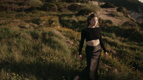 Hermosa mujer parada en un campo azotado por el viento