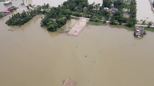 Aerial view of flooded village with submerged road, home and trees in Bangladesh, South Asia