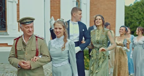 Wedding Party Walking in Front of Brick Building