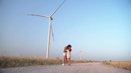 Happy Woman Mother Child Girl Walking Dancing Spinning Turn Around in a Wind Farm
