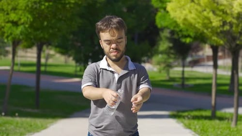 Dwarf young man drinking water. Water for healthy life.