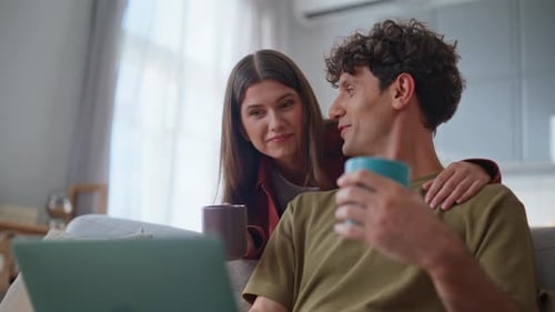 Couple Relaxing at Home with Laptop Computer