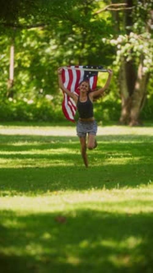 Young Girl Running With American Flag in Park