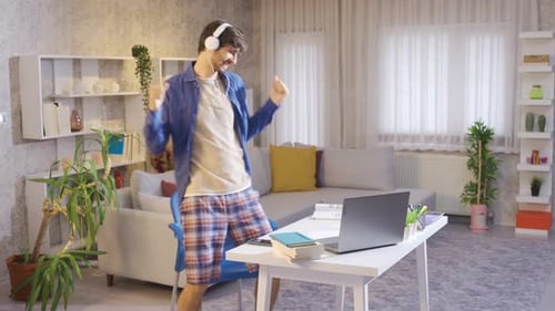 Young Adult Dancing While Using Laptop