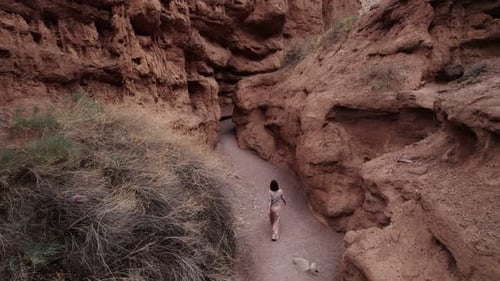 Ein Mädchen geht durch eine Schlucht in Kirgisistan