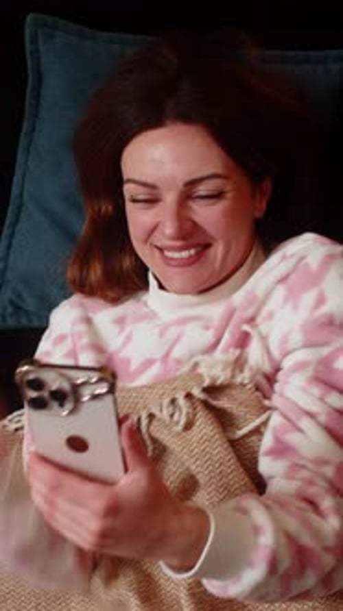 Woman Lies on Couch and Looks at Phone