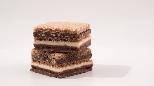 Delicious chocolate wafers with hazelnuts rotate on a white background.