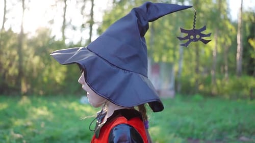 Child Dressed as Witch outdoors in Grassy Field