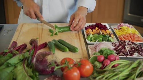 Man Cutting a Variety of Vegetables in Kitchen Baker