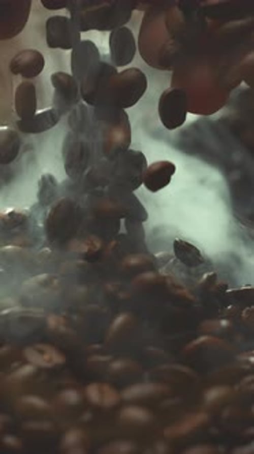 Super Slow Motion Shot of Falling Roasted Coffee Beans From Hand with Smoke in Macro Vertical Close