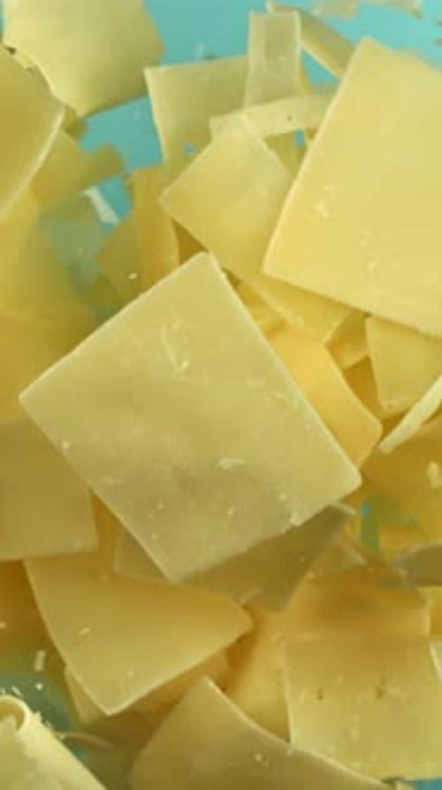 Parmesan Cheese Flies Up and Falls Down on a Blue Background Filmed on a Highspeed Camera at 1000