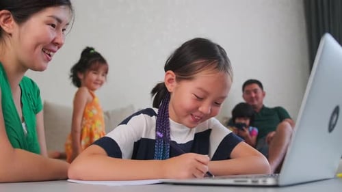 Mother Helping Child With Homework and Laptop