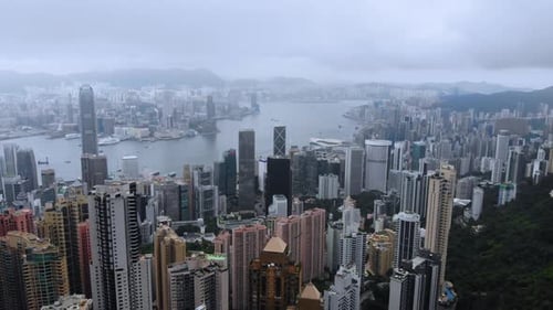 4K aerial shot from Victoria Peak capturing the beauty of Hong Kong during a cloudy afternoon.