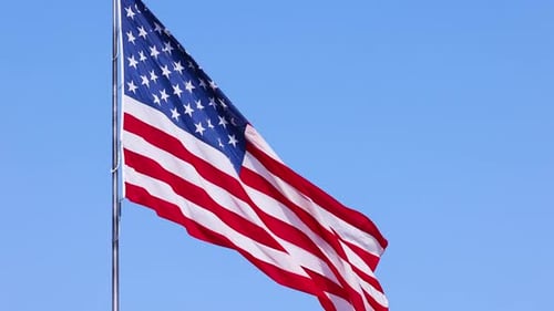 US Flag on a flagpole blowing in the breeze