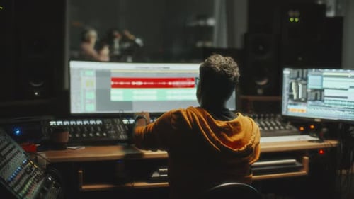 Audio Engineer Mixing Tracks in Professional Recording Studio