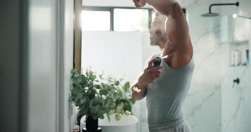 Man Applies Deodorant in Modern Bathroom Setting