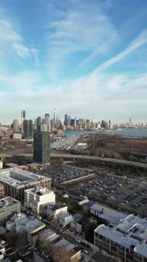 Aerial wintertime view of Jersey City and the Manhattan skyline under blue skies with broken cloud